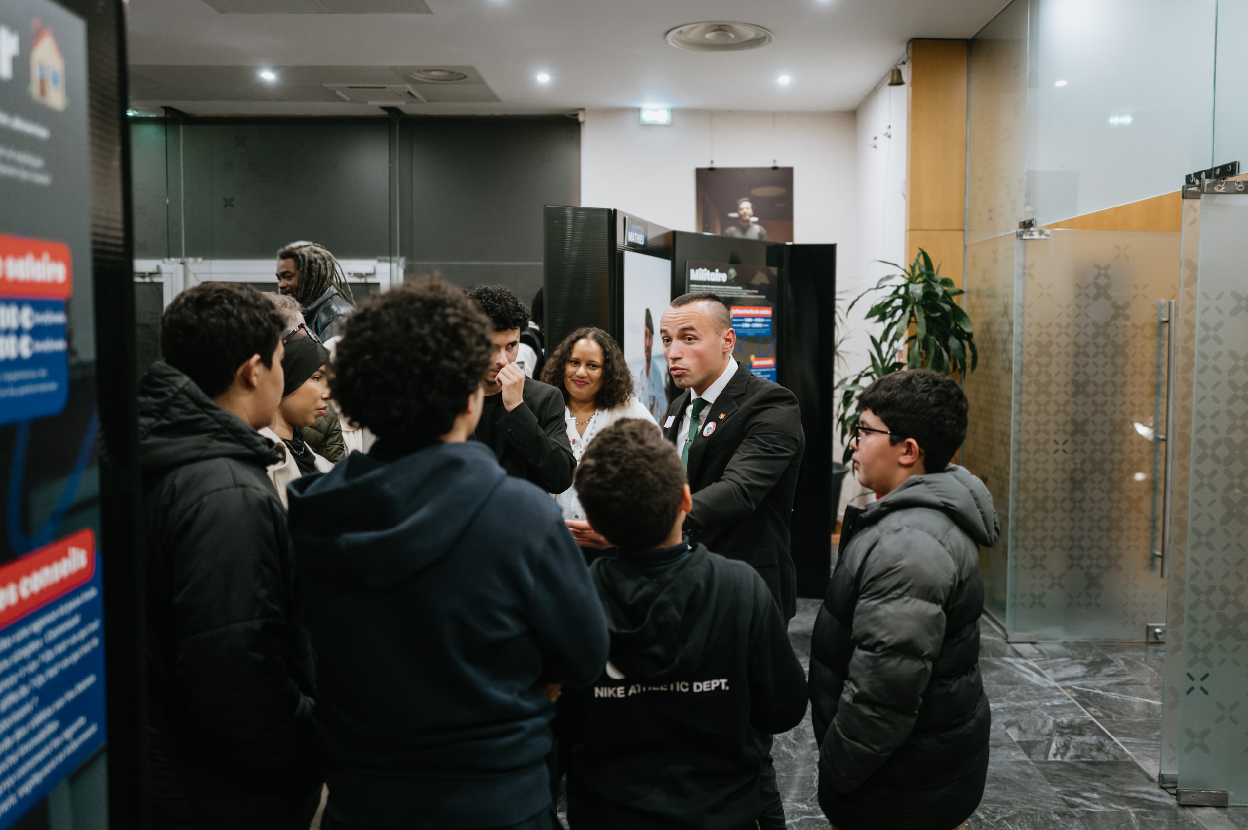 Professionnel échangeant avec un groupe de jeunes pendant le vernissage de l’exposition Imagine au Palais du Pharo en 2024
