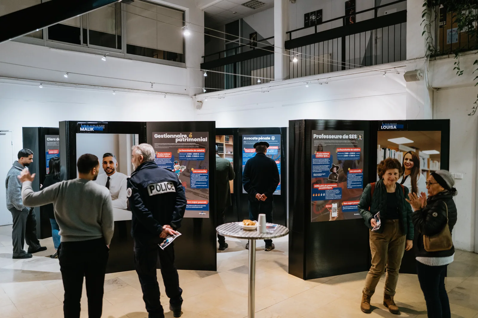 Vue globale d’une exposition Imagine avec panneaux métiers et visiteurs
